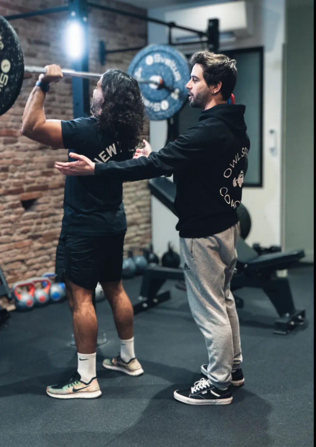 Lucas accompagne un client en salle de musculation